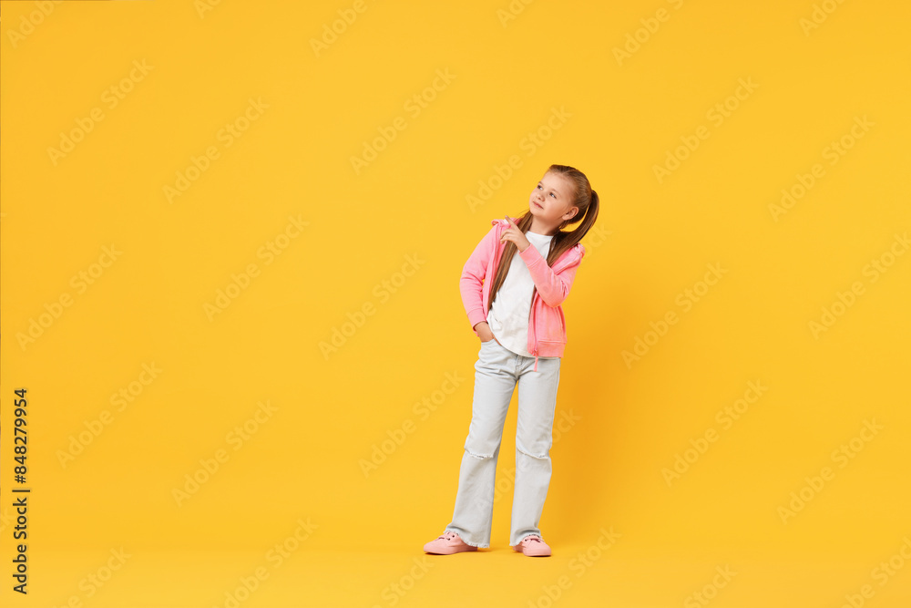 Cute little girl dancing on yellow background, space for text Cute little girl dancing on yellow background, space for text