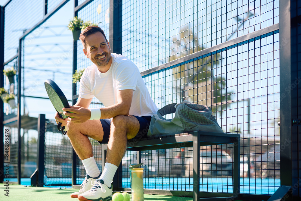 Fototapeta premium Happy athlete relaxing after playing paddle tennis outdoors.