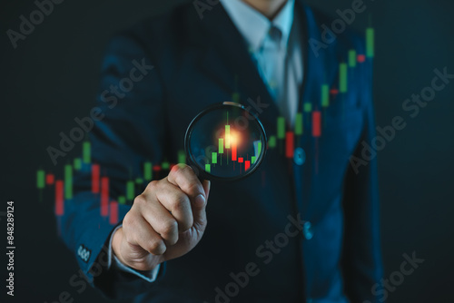 Businessman hold a magnifying glass for concept of stock market trading analysis, Digital technology strategy for business growth, Financial investment stock market by AI assistant tech
