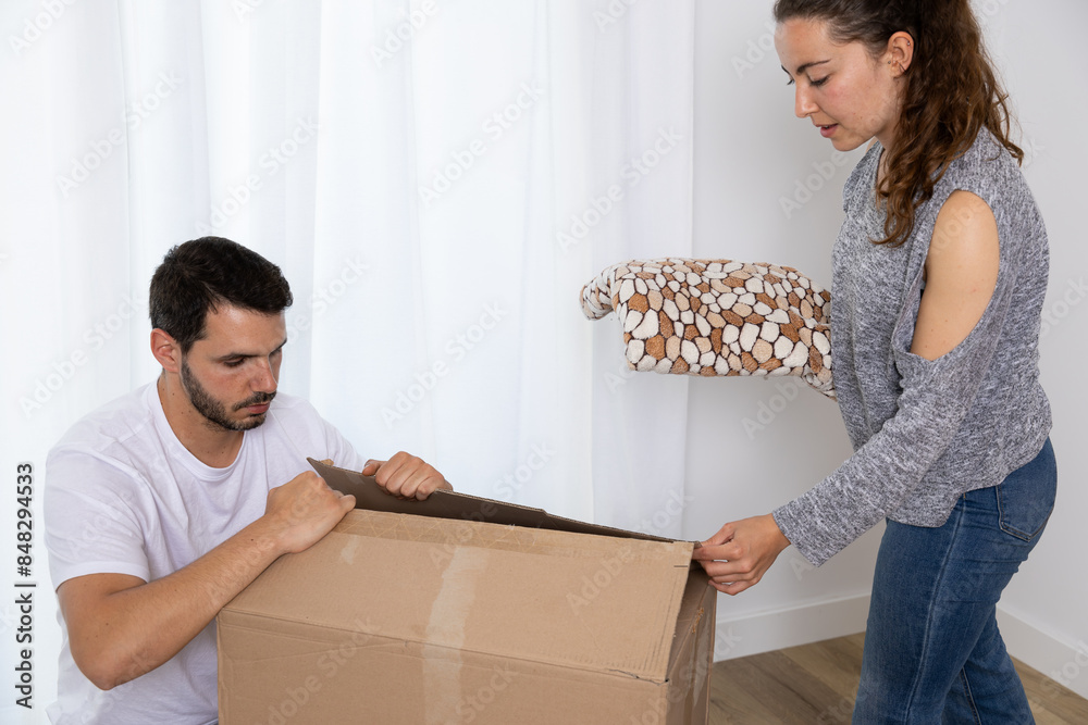 Happy couple packing their stuff to move into their new owned house. They are homeowners, mortgage concept. New home, new life Happy couple packing their stuff to move into their new owned house. They are homeowners, mortgage concept. New home, new life