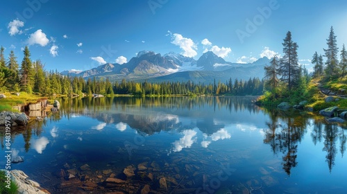 A breathtaking view of a mountain lake reflecting the sky and surrounding forested landscape under clear blue skies