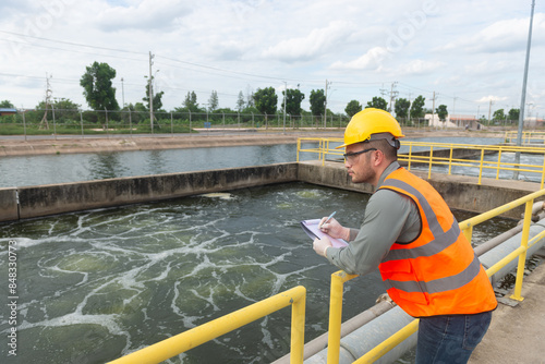 Vászonkép an engineer stand aside at the waste water pool and check the list on clipboard