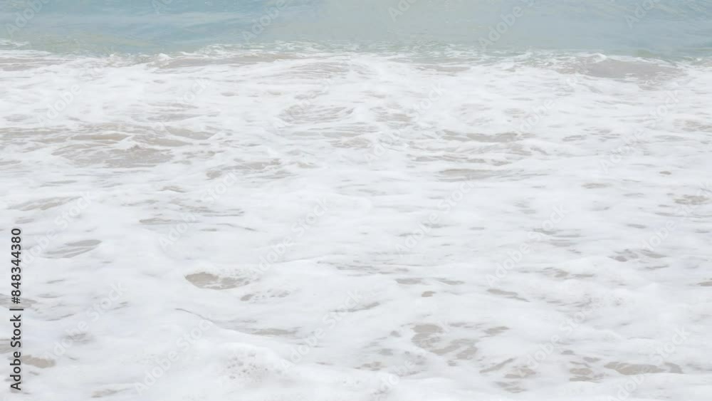 view to summer sea water wave while hitting white sand natural beach with water splash in foaming view to summer sea water wave while hitting white sand natural beach with water splash in foaming