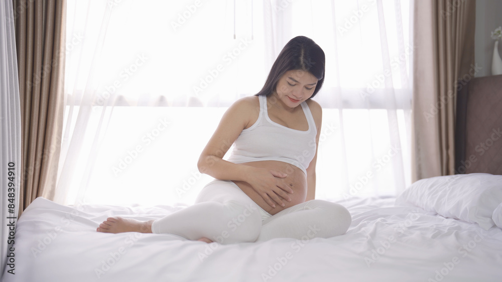 A Portrait of happy Asian pregnant woman in bedroom at home. Having a baby. Family people lifestyle. Love. A Portrait of happy Asian pregnant woman in bedroom at home. Having a baby. Family people lifestyle. Love.