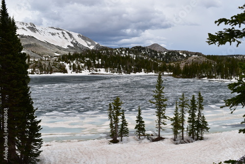 View of the partially frozen Lake Marie and the Medicine Bow-Routt mountains from the shoreline photo