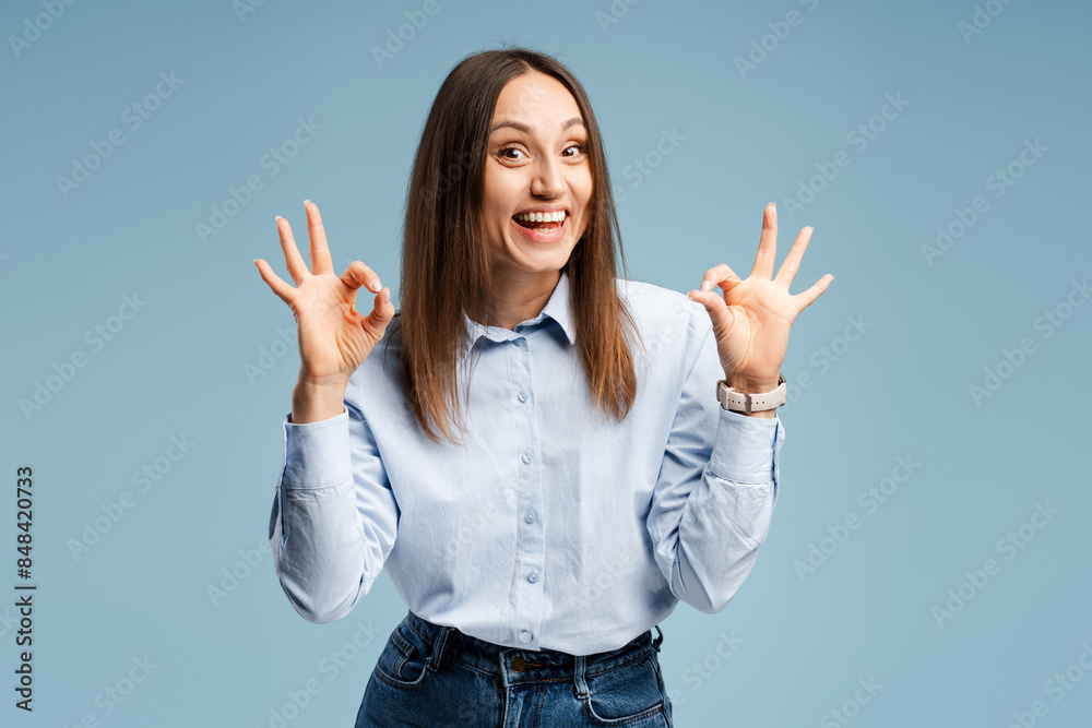 Happy Caucasian young woman with wide smile wearing casual showing ok symbol with fingers Happy Caucasian young woman with wide smile wearing casual showing ok symbol with fingers