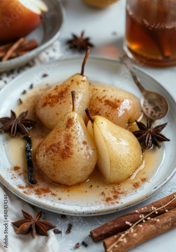 Three Poached Pears With Cinnamon and Star Anise on a White Plate