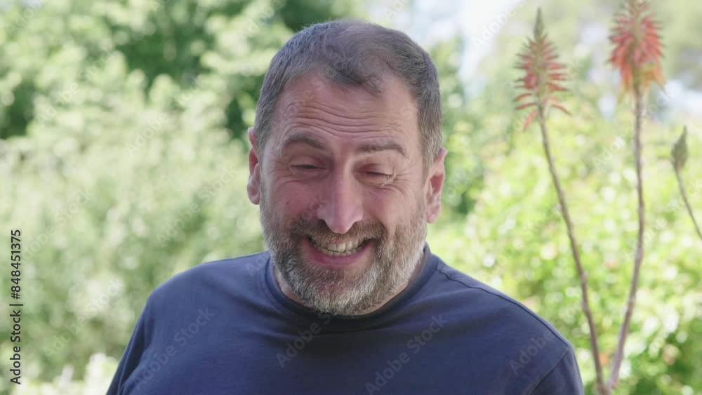 Middle-aged man in blue shirt smiling at camera outdoors Middle-aged man in blue shirt smiling at camera outdoors
