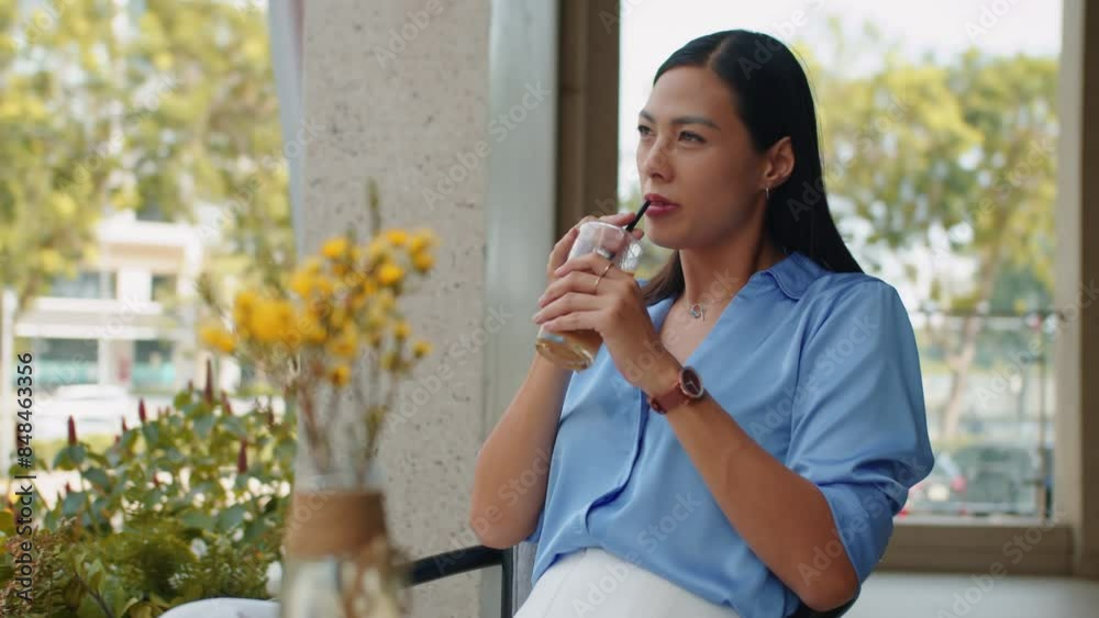 Medium shot of Asian female entrepreneur enjoying morning coffee in outdoor cafe before work Medium shot of Asian female entrepreneur enjoying morning coffee in outdoor cafe before work