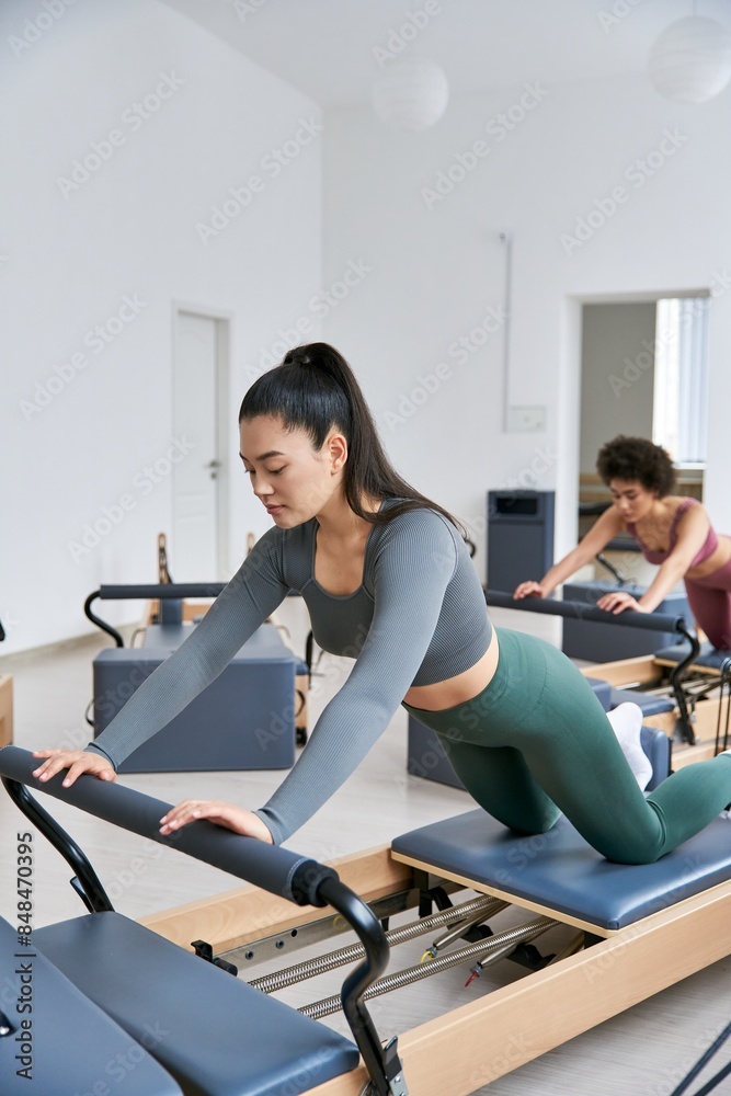Diverse group of women in gym attire exercising together. Diverse group of women in gym attire exercising together.