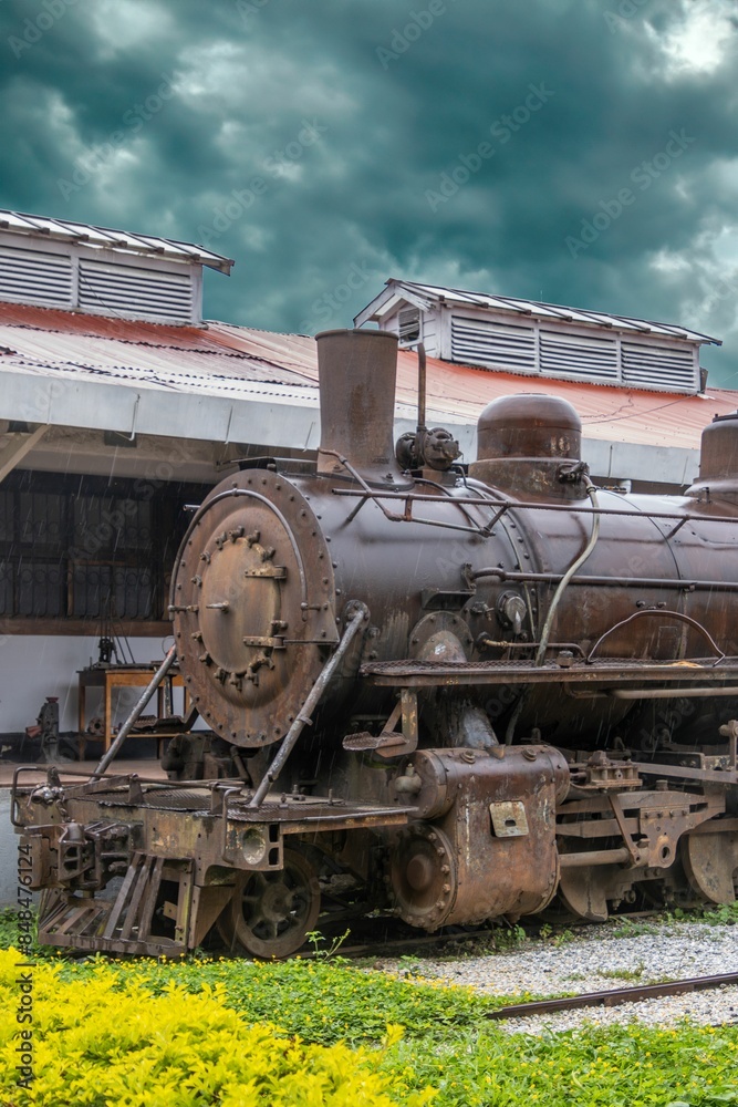 Naklejka premium An old steam locomotive on display at a train station