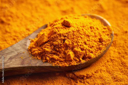 Dried turmeric root powder on a spoon photo