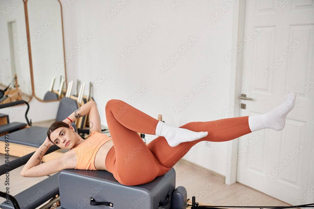 Attractive woman in comfy sportswear practising during pilates lesson. Attractive woman in comfy sportswear practising during pilates lesson.