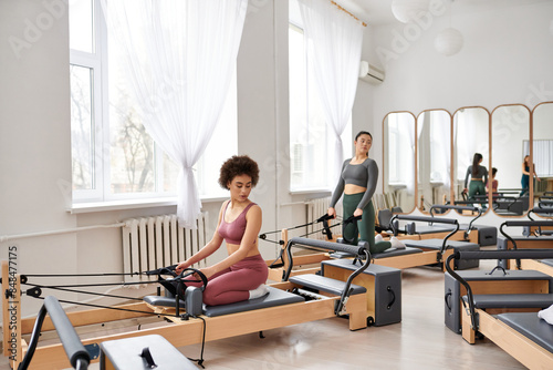 Group of pretty sporty women engaging in a dynamic pilates session at the gym.