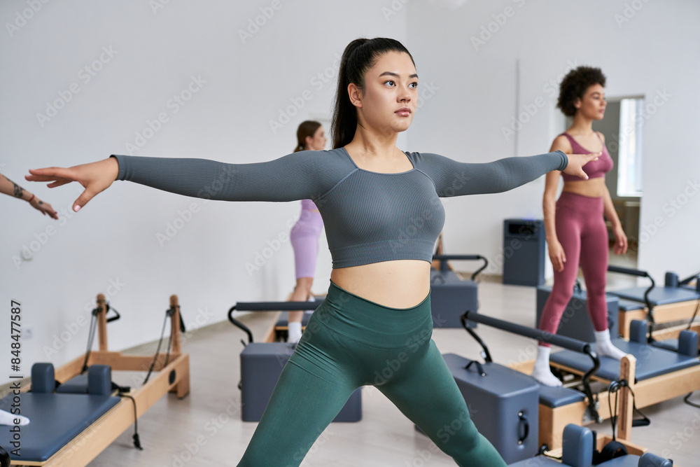 A group of pretty sporty women engaging in a lively pilates class. A group of pretty sporty women engaging in a lively pilates class.