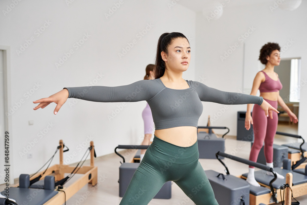 Group of sporty women working out together in a dynamic pilates class. Group of sporty women working out together in a dynamic pilates class.