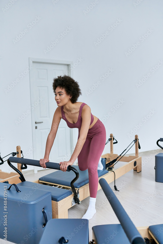 A woman gracefully performs pivots on a rowing machine. A woman gracefully performs pivots on a rowing machine.