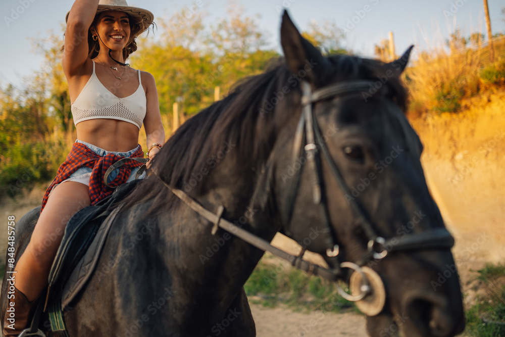 Young rider in western outfit is horseback riding at homestead. Young rider in western outfit is horseback riding at homestead.
