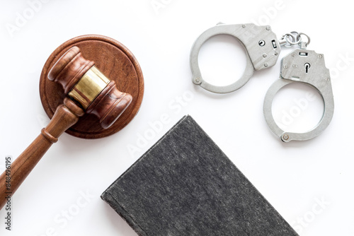 Metal handcuffs with judges gavel and criminal code book. Criminal law and justice concept