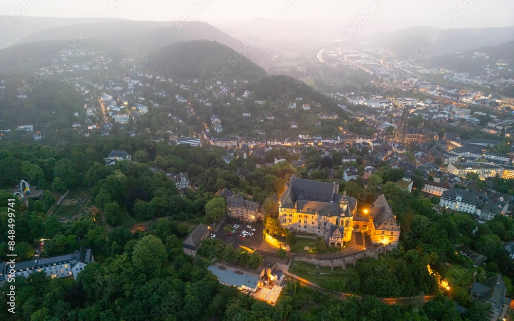 Fototapeta premium Aerial view of Marburg, Germany at dusk showcasing Marburg castle and the surrounding town.