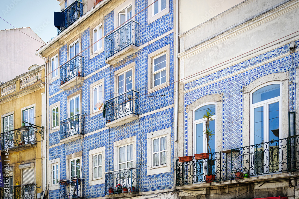 Naklejka premium typical lisbon residential building with the tiled façade and the balconies with the ornate wrought-iron railings