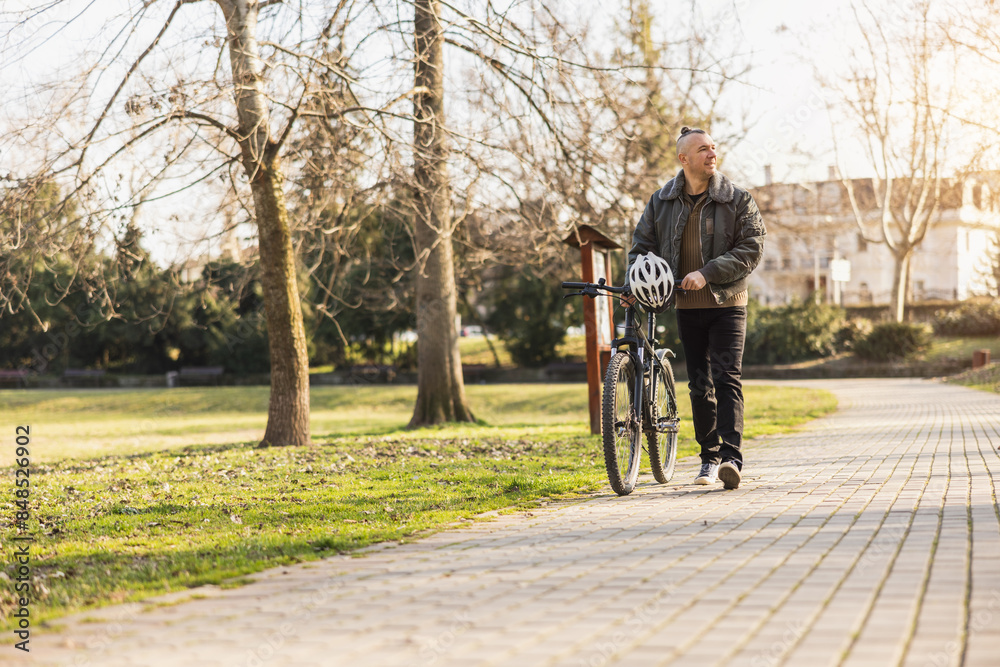 Man Walking With Bike In City Park Man Walking With Bike In City Park