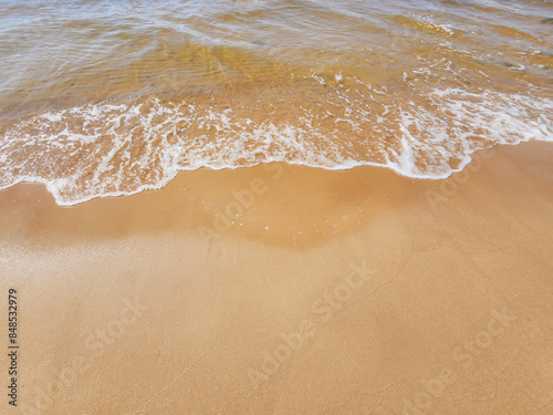 A tranquil beach scene with gentle waves lapping on a sandy shore, capturing the essence of peacefulness