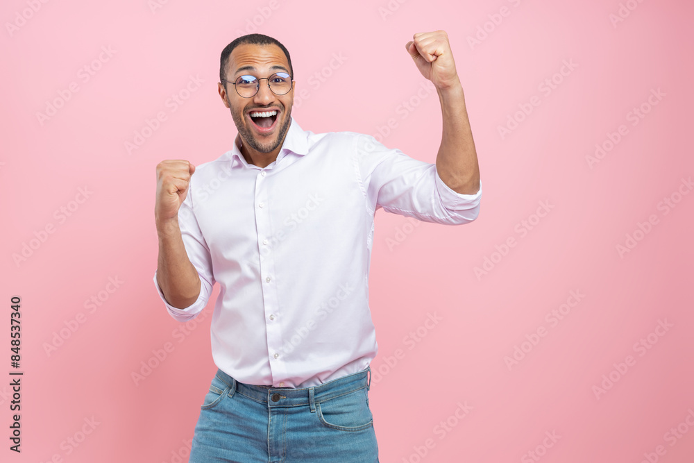 Extremely happy man in white shirt raising hands celebrating victory Extremely happy man in white shirt raising hands celebrating victory
