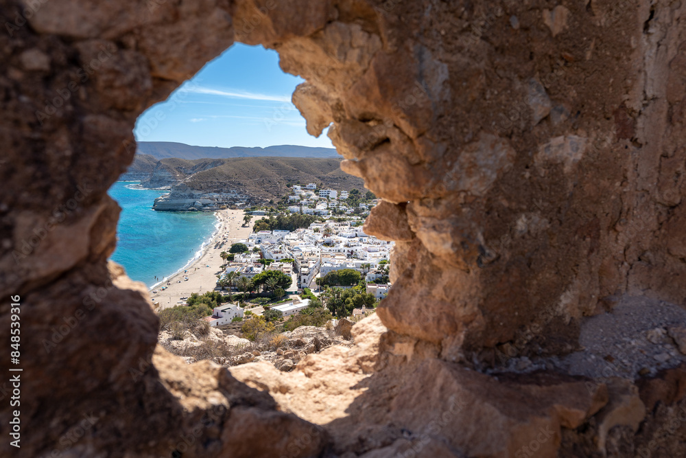 Fototapeta premium Overview of Agua Amarga Village Through Ruined Wall Gap