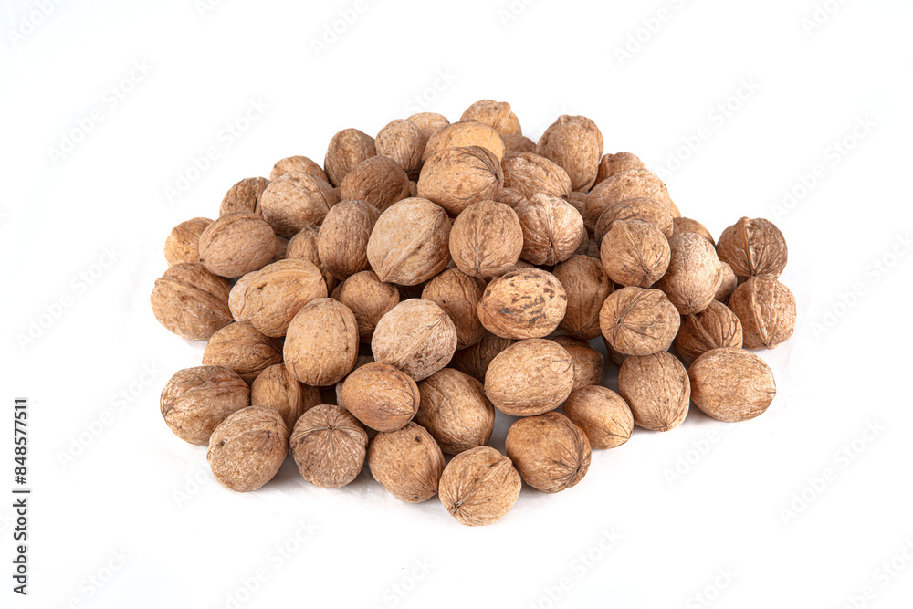 Walnut kernels in a wooden bowl and whole walnuts on table. Close up of metal pliers to open nuts with walnut nutcracker. Walnut kernels in a wooden bowl and whole walnuts on table. Close up of metal pliers to open nuts with walnut nutcracker.
