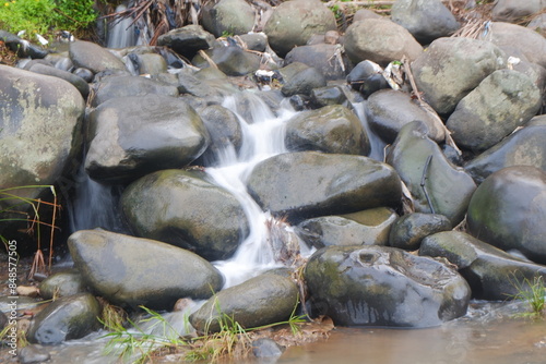 water flowing between the rocks in a small river photo