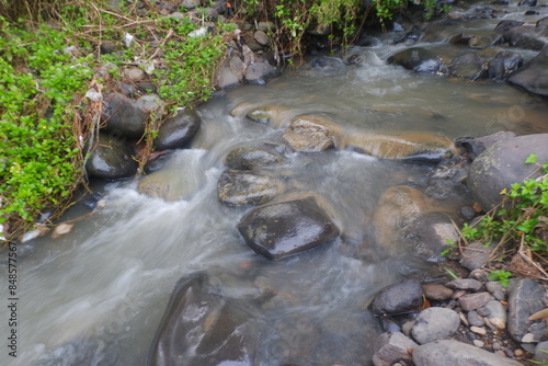 water flowing between the rocks in a small river photo