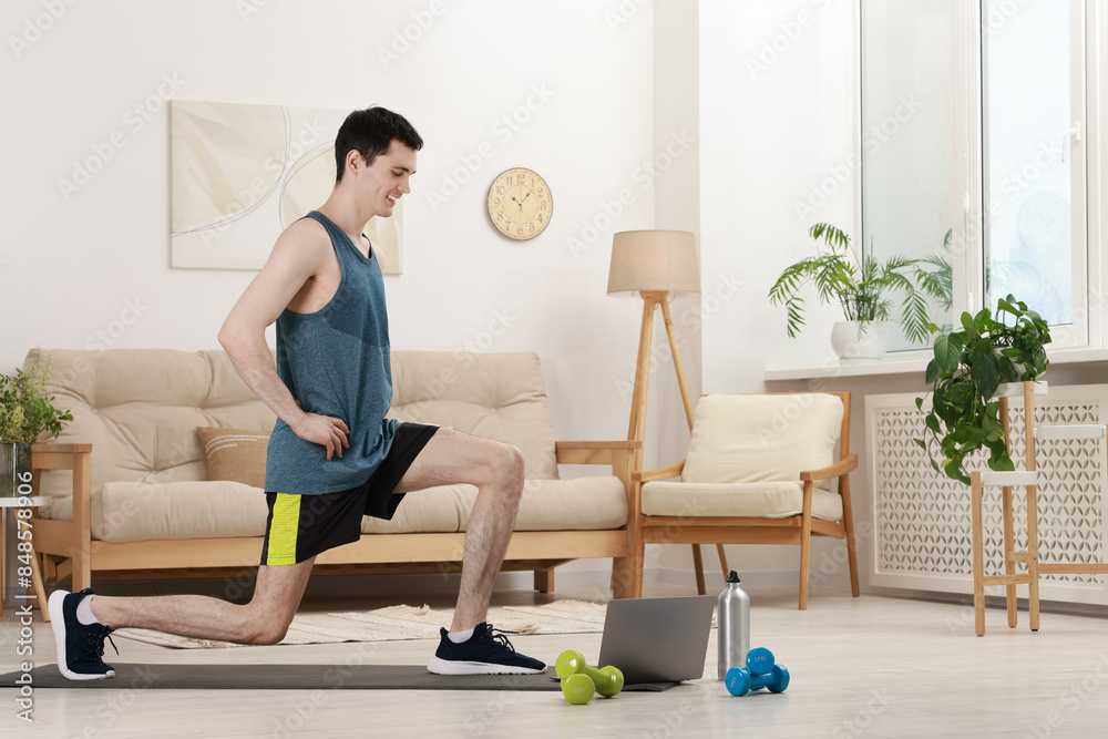 Online fitness trainer. Man doing exercise near laptop at home Online fitness trainer. Man doing exercise near laptop at home