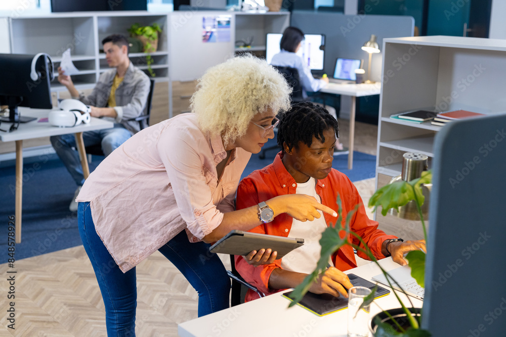 Biracial woman and African American man team up on startup tech project in business Biracial woman and African American man team up on startup tech project in business