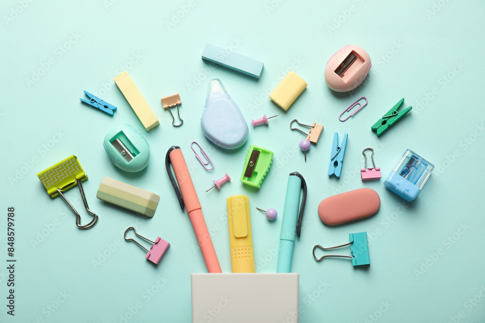 Flat lay composition with holder and different stationery on turquoise background Flat lay composition with holder and different stationery on turquoise background