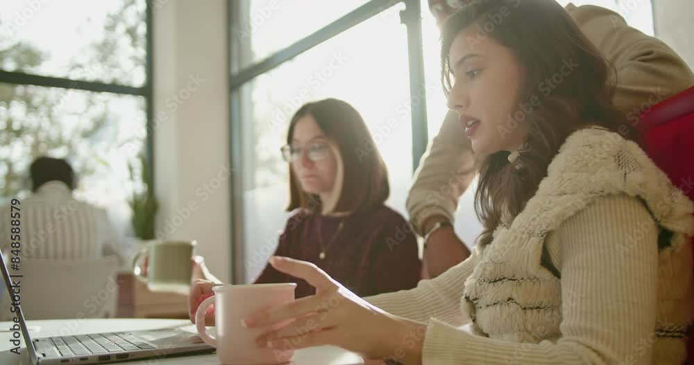 In a business setting, young female employees discuss over a laptop, analyzing statistics and brainstorming ideas, showcasing their analytical skills and collaborative approach to problem-solving. In a business setting, young female employees discuss over a laptop, analyzing statistics and brainstorming ideas, showcasing their analytical skills and collaborative approach to problem-solving.