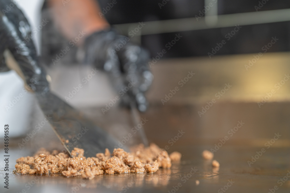 Chopping meat on the griddle in the kitchen Chopping meat on the griddle in the kitchen
