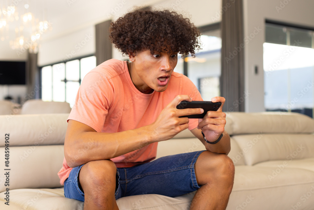 Excited biracial man watching sports on smartphone online Excited biracial man watching sports on smartphone online
