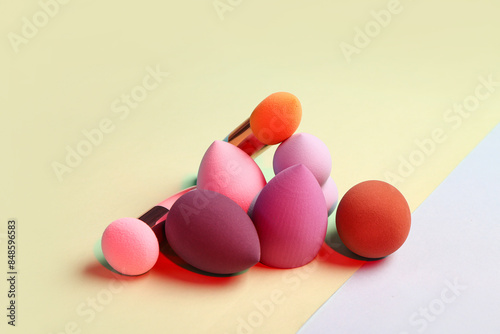 Different makeup sponges on colorful background © Pixel-Shot