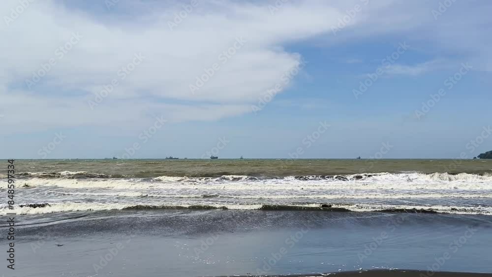 The atmosphere of the waves crashing on the beach, during a sunny day The atmosphere of the waves crashing on the beach, during a sunny day