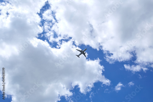 An airplane is in a blue sky with beautiful white clouds.  photo