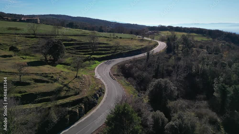 Winding road through the lush, green countryside of Tavertet, Barcelona, on a clear, sunny day Winding road through the lush, green countryside of Tavertet, Barcelona, on a clear, sunny day