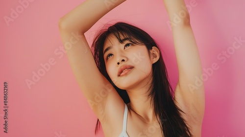 Beautiful young Asian woman lifting hand up to shows off clean and clear armpit or underarms isolated on pink background Smooth and freshness armpit concept : Generative AI