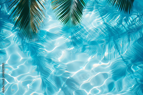 Abstract background with palm leaves shadow on the water in swimming pool, top view. summer concept. banner with copy space area © Ikhou