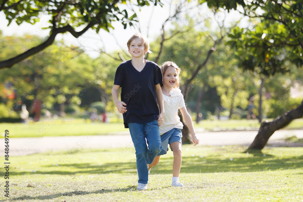 Fototapeta premium White children running together at the park.