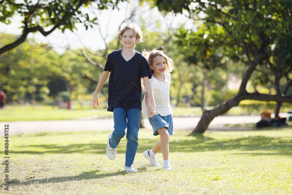 White children running together at the park. White children running together at the park.