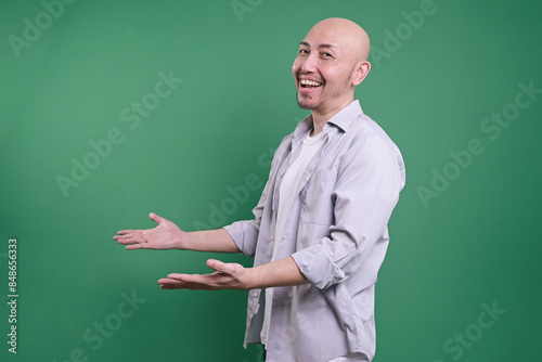 Side View Of A Smiling Bald Man With Open Arms Posing © Gatot