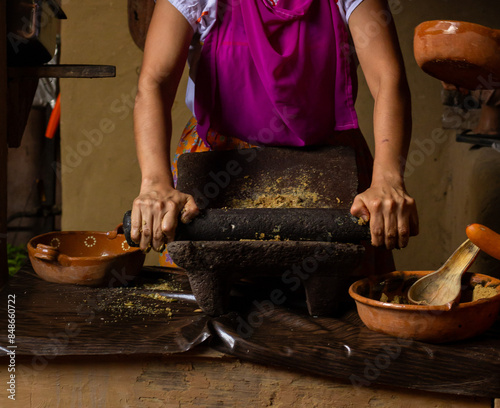 Latin woman traditional cook in the metate, hands cooking in a traditional way
