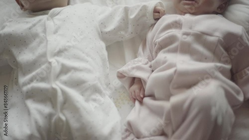Close twins lying on futon with their hands on top of each other's (4)
