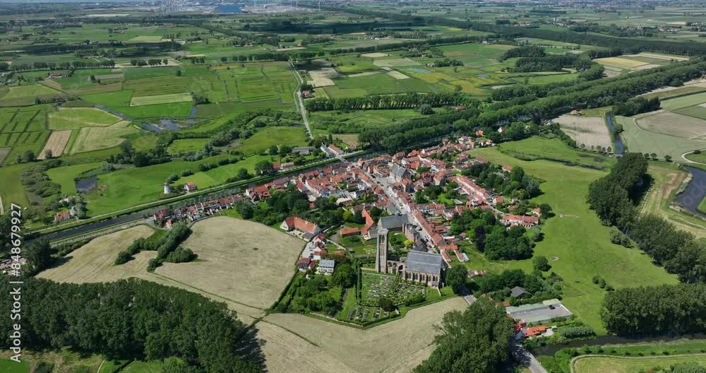 Damme, Belgium, June 2022. Drone in a high angle aerial static position showcasing Stadhuis Damme and Our Lady Ascension Church surrounded by the picturesque village and lush green fields. Damme, Belgium, June 2022. Drone in a high angle aerial static position showcasing Stadhuis Damme and Our Lady Ascension Church surrounded by the picturesque village and lush green fields.